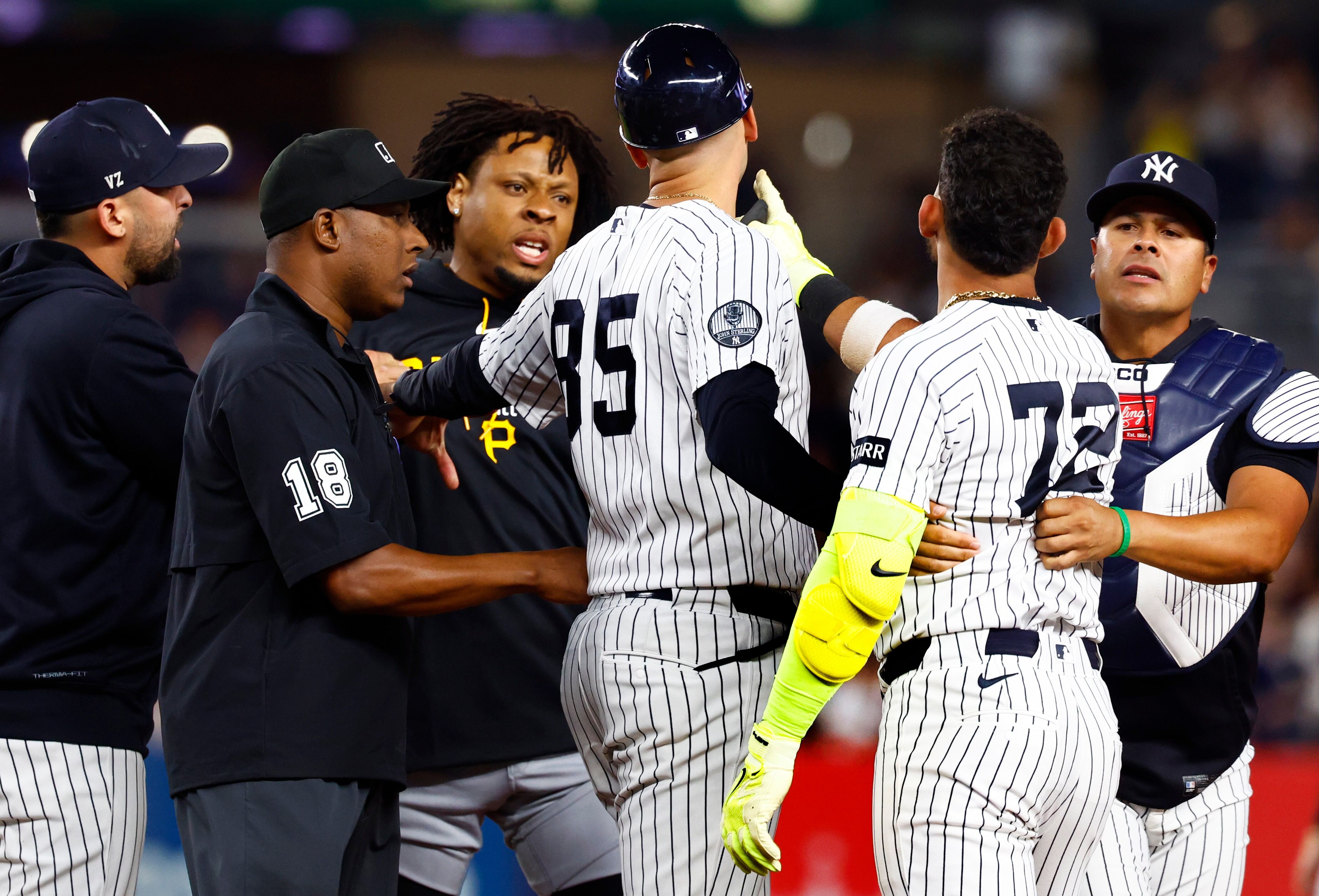 Pirates' Santana confronts Yankees' Caballero over pitch clock pace, clearing both benches.