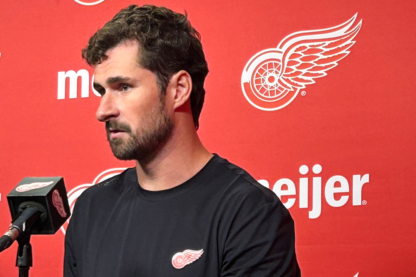Injured Dylan Larkin attends Red Wings training camp amid ongoing trade uncertainty.